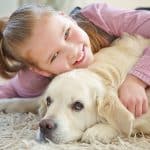 girl hugging her pet dog