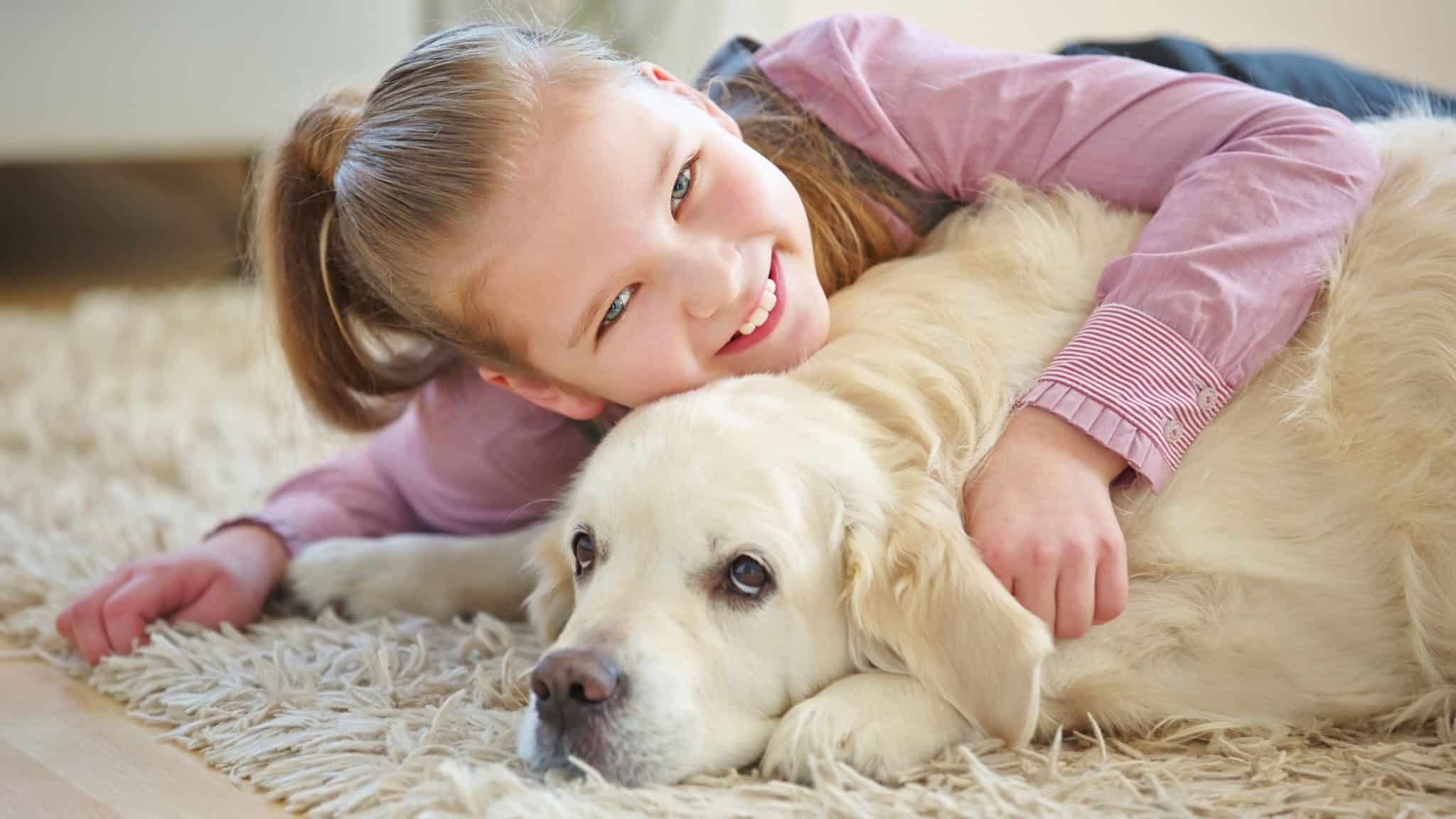 girl hugging her pet dog