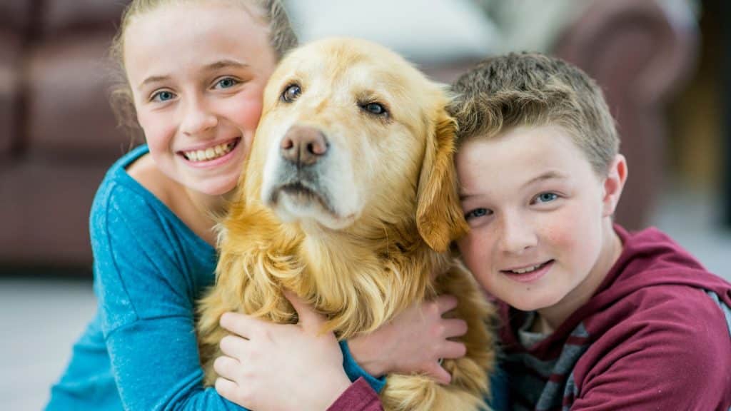 kids hugging dog